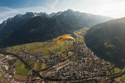 Blick von oben auf Lienz, ein Gleitschirm über dem Tal